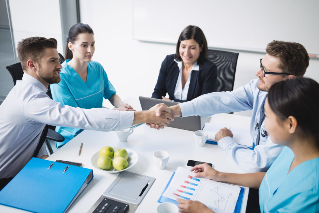 doctors shaking hands with each other in meeting at conference room